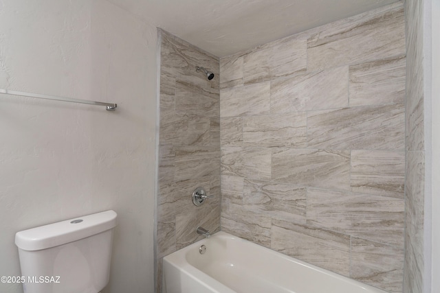 bathroom featuring tiled shower / bath and toilet