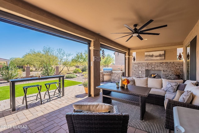 view of patio / terrace with an outdoor kitchen, an outdoor living space with a fireplace, and ceiling fan