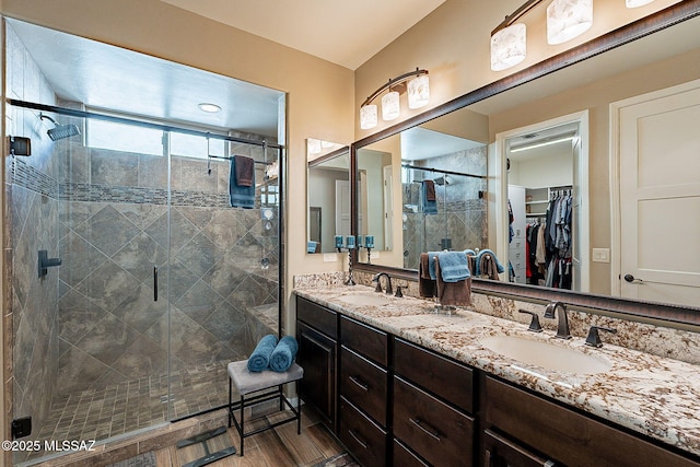 bathroom featuring an enclosed shower, vanity, and wood-type flooring