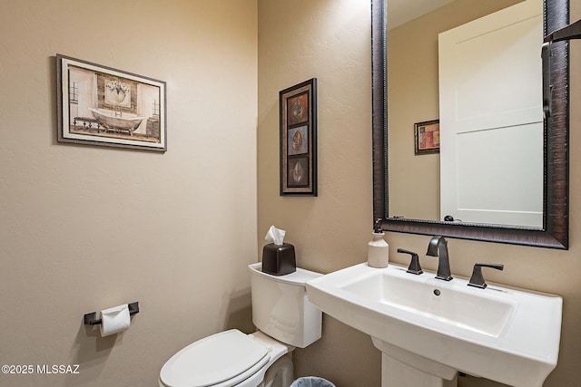 bathroom featuring toilet and sink