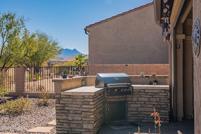 view of patio / terrace featuring area for grilling, a mountain view, and an outdoor kitchen