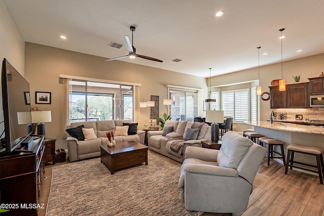 living room with ceiling fan and light hardwood / wood-style floors