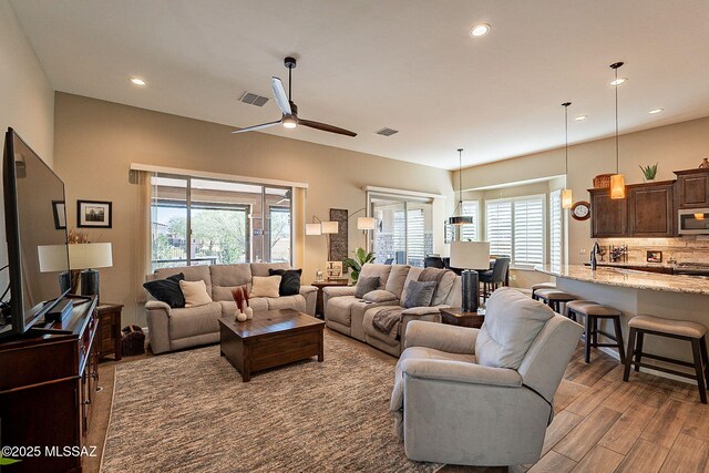 living room featuring hardwood / wood-style floors and ceiling fan