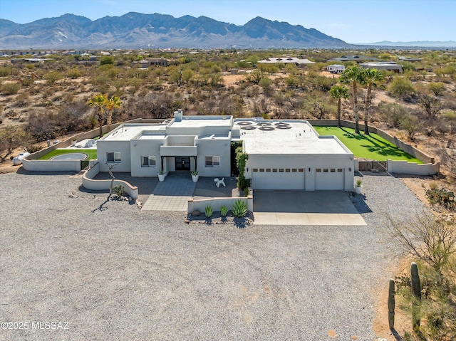 view of front of home featuring concrete driveway, fence, a mountain view, and stucco siding