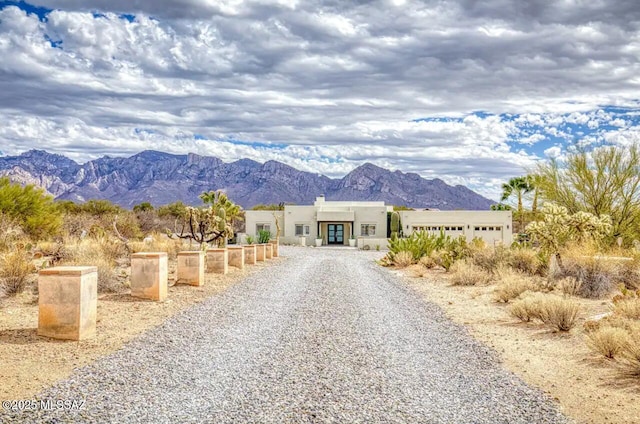 view of front of house featuring an attached garage, a mountain view, and stucco siding