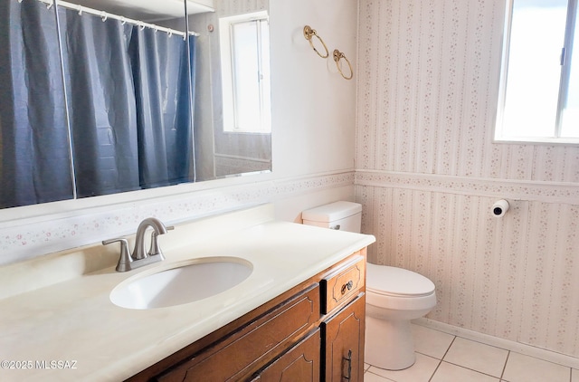 bathroom featuring tile patterned flooring, vanity, a healthy amount of sunlight, and toilet