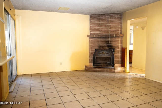 unfurnished living room featuring light tile patterned floors, a textured ceiling, and a fireplace