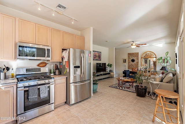 kitchen featuring stainless steel appliances, ceiling fan, light tile patterned floors, and light brown cabinetry