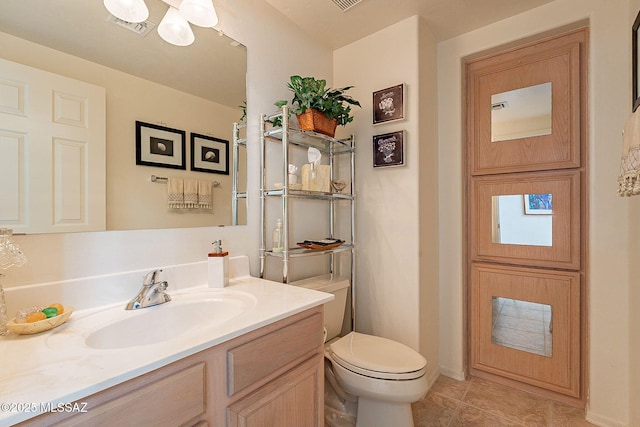 bathroom featuring vanity, a notable chandelier, tile patterned floors, and toilet