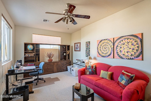 carpeted home office with a healthy amount of sunlight and ceiling fan