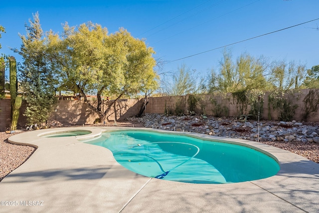 view of swimming pool with an in ground hot tub