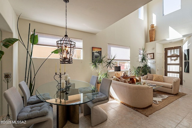 living room featuring light tile patterned flooring, a towering ceiling, and a chandelier