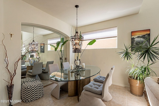 tiled dining area featuring a chandelier