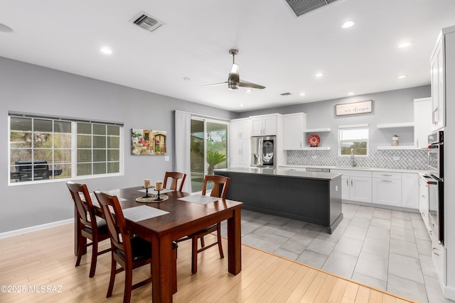 dining room with sink, light hardwood / wood-style floors, and ceiling fan