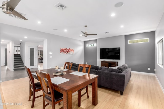 dining space with ceiling fan and light hardwood / wood-style flooring