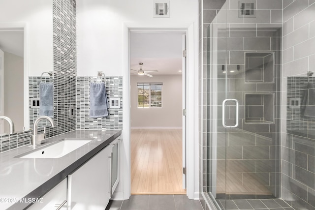 bathroom featuring an enclosed shower, tasteful backsplash, vanity, ceiling fan, and tile patterned flooring