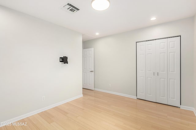 unfurnished bedroom with a closet and light wood-type flooring