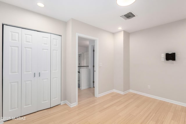 unfurnished bedroom featuring a closet and light wood-type flooring