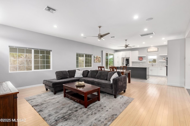 living room with ceiling fan and light wood-type flooring