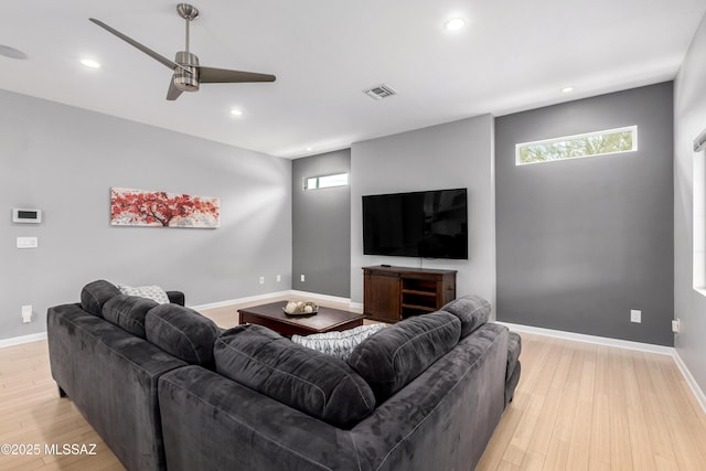 living room with plenty of natural light, light hardwood / wood-style floors, and ceiling fan