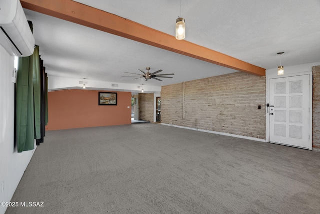 unfurnished living room featuring a wall mounted air conditioner, carpet floors, ceiling fan, brick wall, and beam ceiling