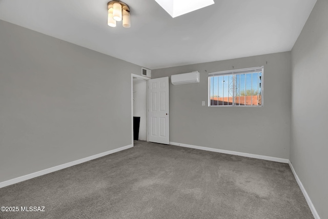 empty room featuring a skylight, an AC wall unit, and carpet