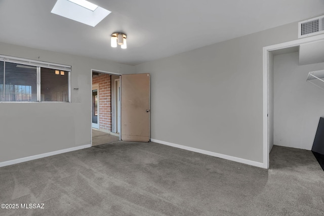 carpeted empty room with a skylight