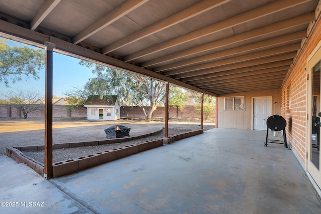 view of patio / terrace featuring a fire pit and an outdoor structure