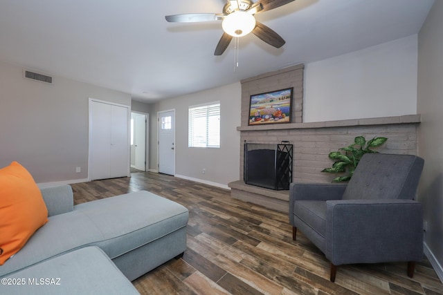 living room with ceiling fan, dark hardwood / wood-style flooring, and a fireplace