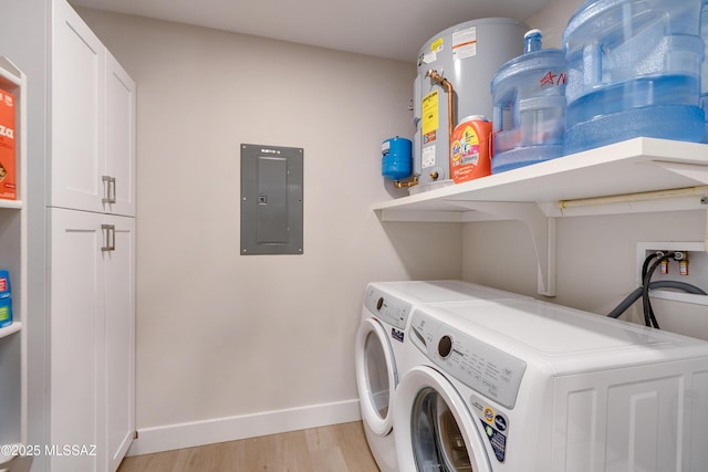 clothes washing area featuring washer and clothes dryer, electric panel, cabinets, and light wood-type flooring