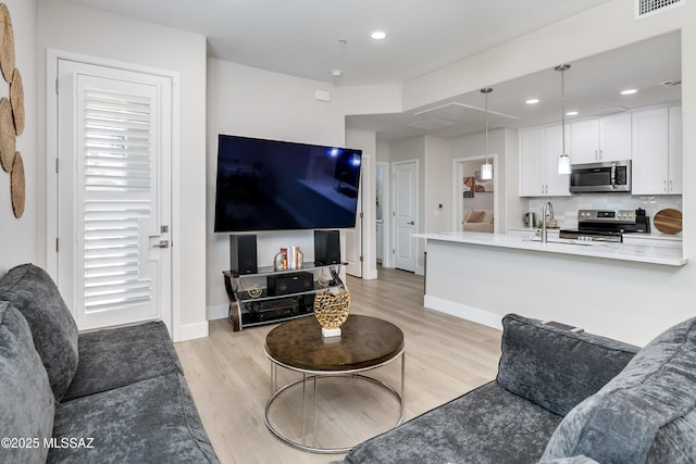 living room with sink and light hardwood / wood-style floors