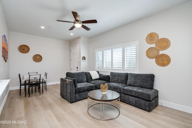 living room with ceiling fan and light hardwood / wood-style flooring