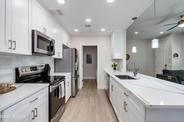 kitchen featuring appliances with stainless steel finishes, sink, hanging light fixtures, and white cabinets