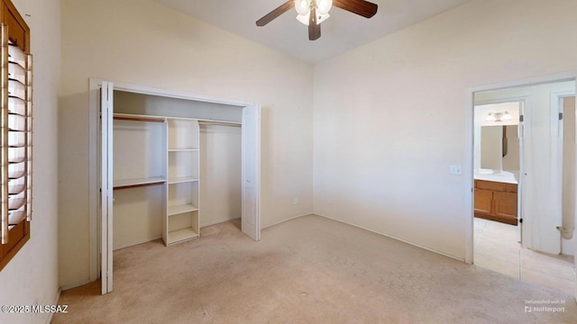 unfurnished bedroom with a closet, light colored carpet, ceiling fan, and light tile patterned floors