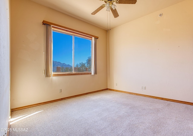 unfurnished room featuring a mountain view, carpet floors, and ceiling fan