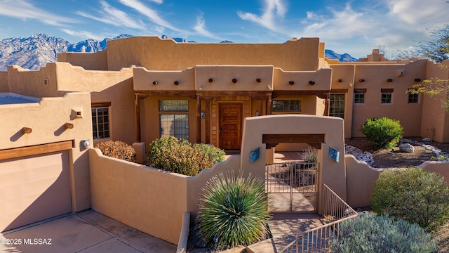 adobe home with a garage and a mountain view