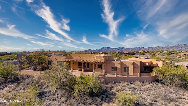 rear view of property featuring a mountain view and a patio