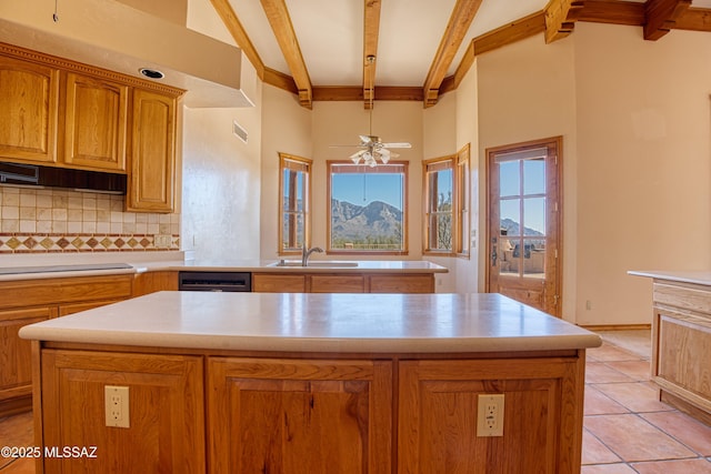 kitchen with sink, backsplash, beamed ceiling, and a kitchen island