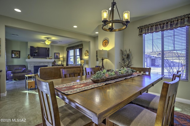 dining space featuring ceiling fan with notable chandelier