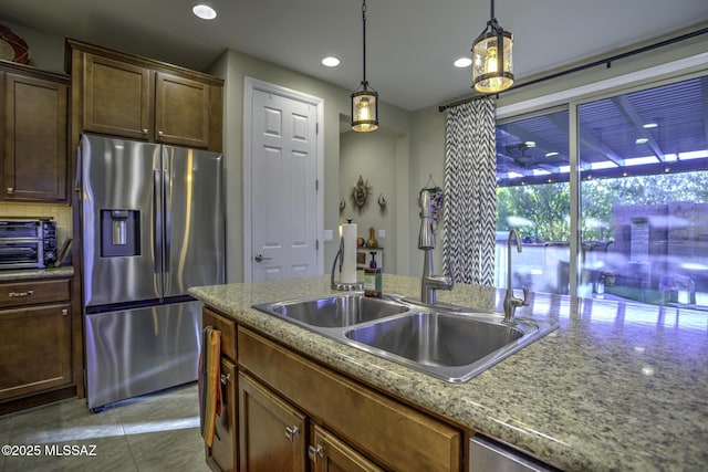 kitchen featuring sink, light stone counters, tasteful backsplash, pendant lighting, and stainless steel appliances