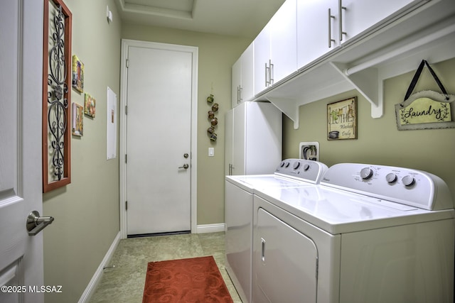 laundry room with separate washer and dryer and cabinets