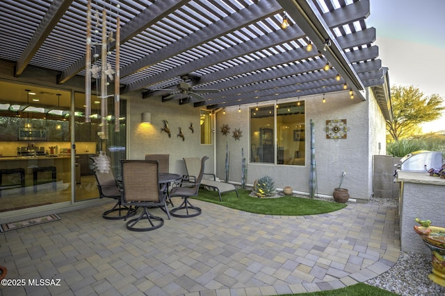 patio terrace at dusk featuring area for grilling and a pergola