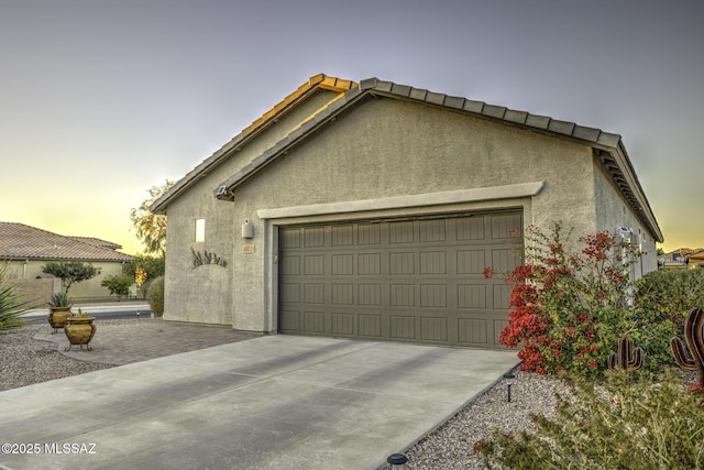 view of garage at dusk