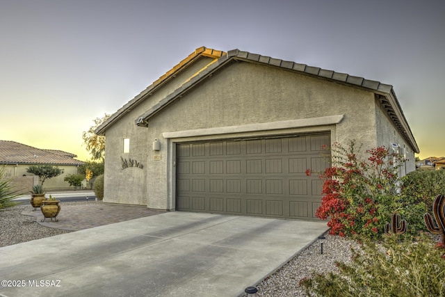 10221 S Rose Wagon Way, Vail, AZ 85641 - garage at dusk featuring concrete driveway
