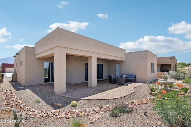 back of property featuring an outdoor hangout area, a patio area, and ceiling fan