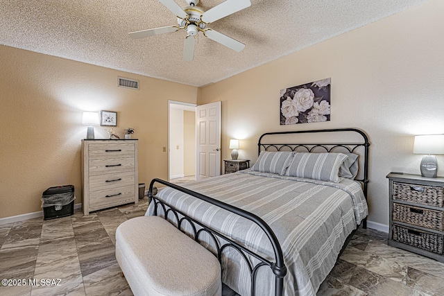bedroom with ceiling fan and a textured ceiling
