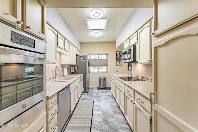kitchen featuring tasteful backsplash, sink, cream cabinets, and stainless steel appliances