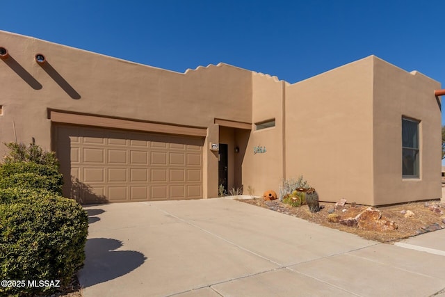 pueblo-style home with a garage