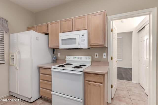 kitchen with white appliances, light tile patterned floors, and light brown cabinets