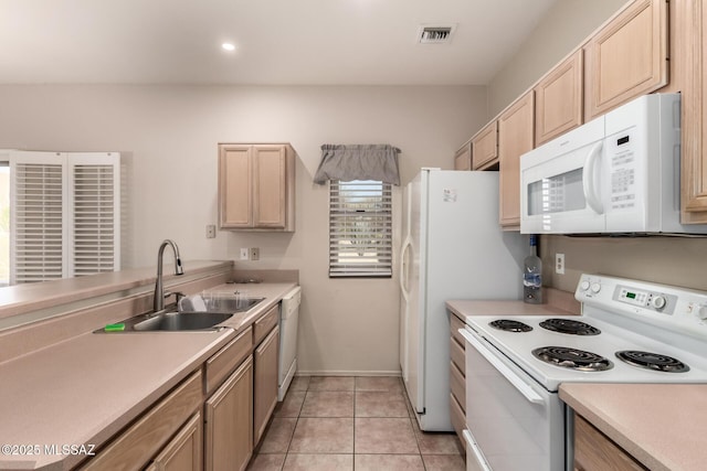 kitchen with white appliances, light brown cabinetry, sink, and light tile patterned floors